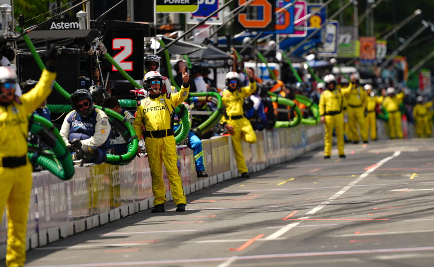 Pit crew members and officials are pictured during the IndyCar Freedom 250 Grand Prix auto race.