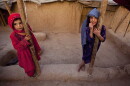 FILE: Zareena, left, and Shakeela, internally displaced Afghan girls play outside a shanty at a refugee camp in the outskirts of Kabul, Afghanistan, Monday, July 25, 2011.