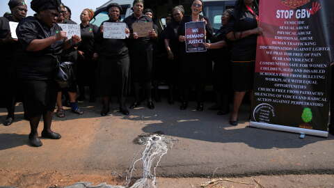 Members of a women's church group sing next to a melted candle as they pay their respects at the site where the body of a woman was discovered the previous week, in Kempton Park, South Africa, east of Johannesburg, Thursday, Sept. 17, 2026.