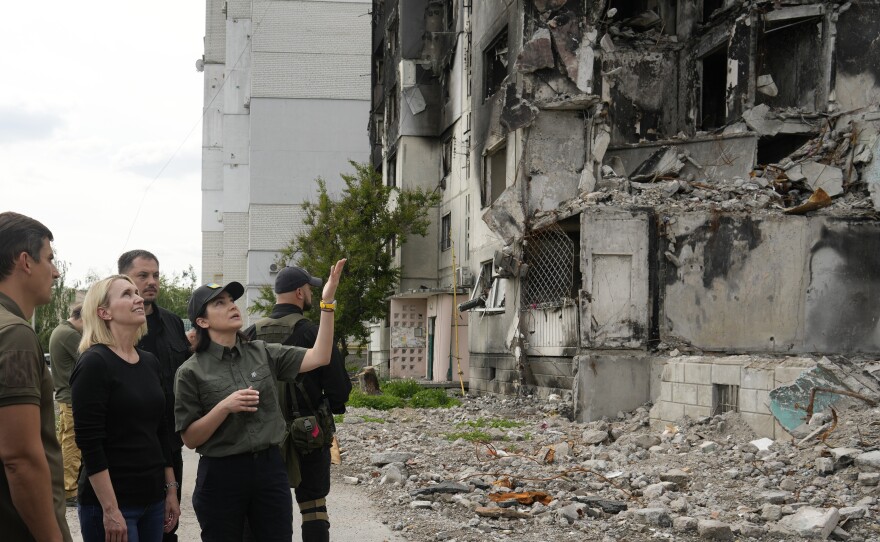 U.S Ambassador to Ukraine Bridget Brink (left) receives a briefing from Ukraine's Prosecutor General Iryna Venediktova in the badly damaged Kyiv suburb of Borodyanka on June 4. Ukraine says it's documented more than 15,000 potential Russian war crimes, and the U.S. government is funding Ukrainian efforts to investigate.