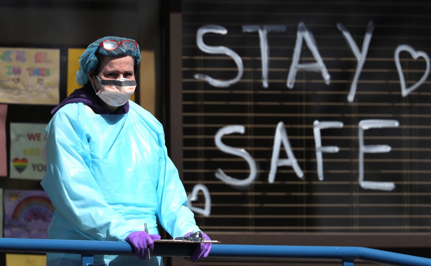 A health care worker staffs a drive-through coronavirus testing site in Jericho, N.Y., a state that remains the hardest hit by the COVID-19 pandemic. The disease has killed more than 10,000 people in the U.S., including 4,758 in New York.