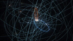 This image traces the orbital paths of all known stars orbiting the massive black hole at the center of the Milky Way galaxy. One of the stars, S301, approaches the black hole very closely. At its closest approach, the star travels over 15,000 miles per second.