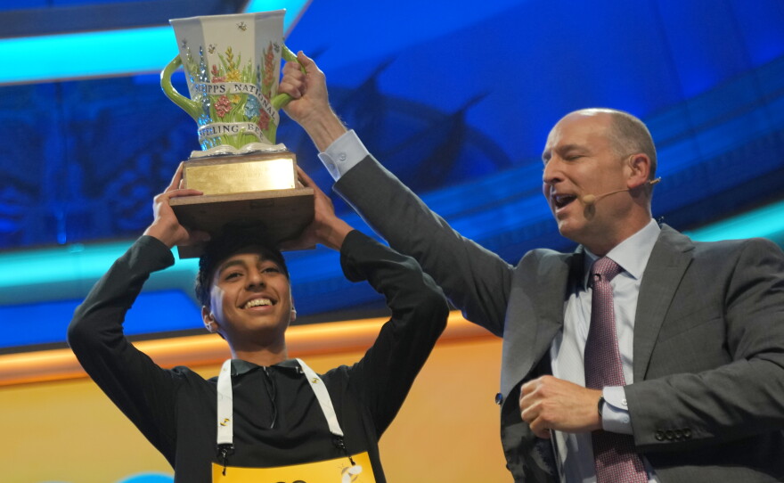 E.W. Scripps Company president and CEO Adam Symson holds the trophy over Shrey Parikh, winner of the 2026 Scripps National Spelling Bee, at DAR Constitution Hall in Washington, D.C. on Thursday.