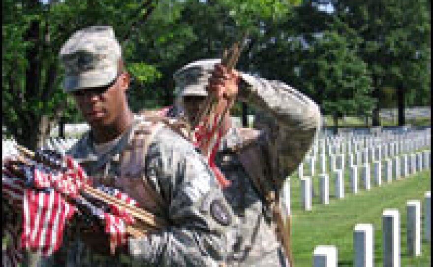 Pfc. Gabriel Gonzales (right) makes sure that Staff Sgt. William Peyton has a few rows' worth of flags in his rucksack.