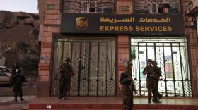 Yemeni security are seen outside a branch of the U.S. package delivery firm UPS in San'a on Saturday.