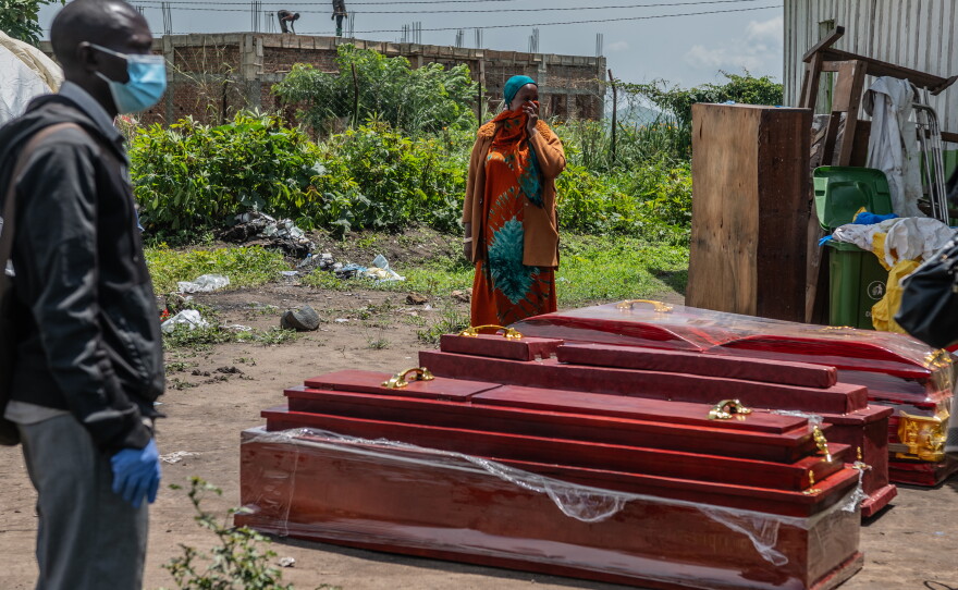 Family members of people who died of Ebola stand next to coffins at a health center in Rwampara, Congo, Wednesday, May 20, 2026.