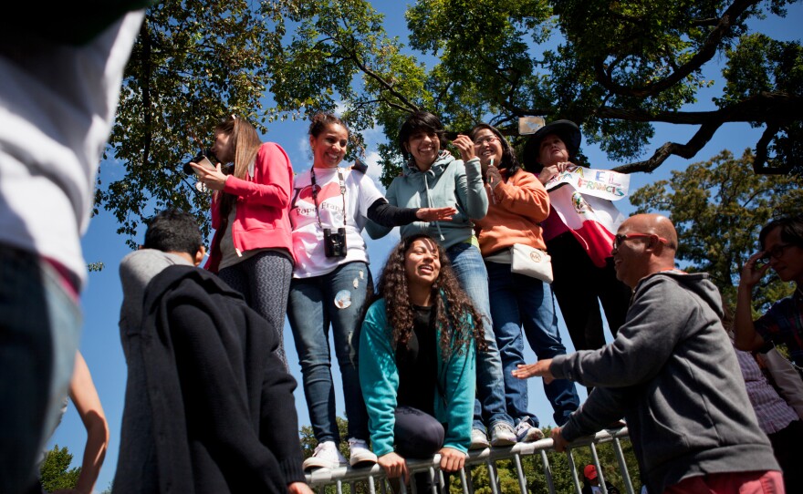 Spectators anticipate Pope Francis' arrival on Constitution Avenue during the papal parade.