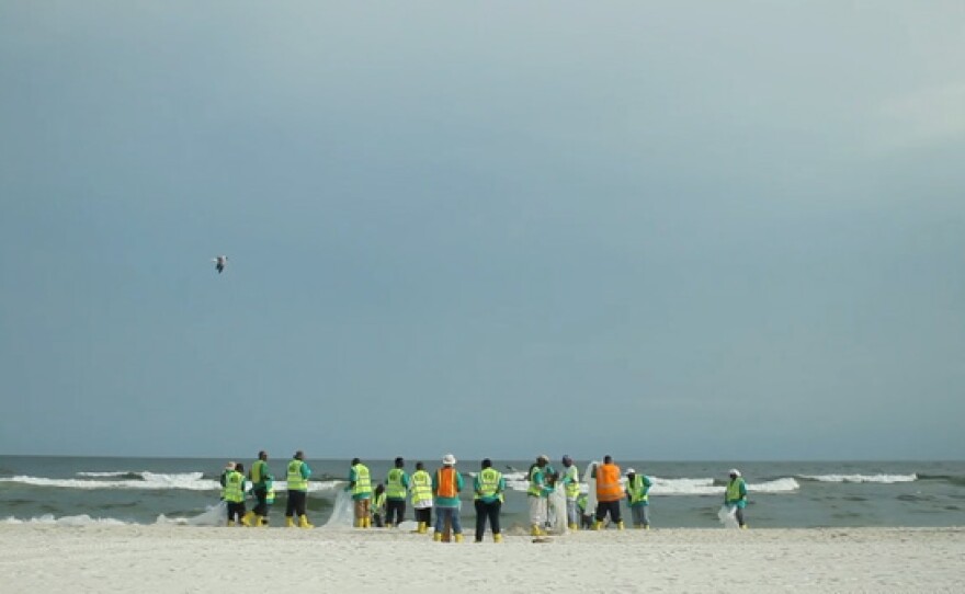 Cleanup crews on the beach in Alabama.