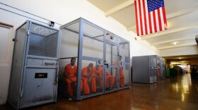 Inmates at California's Chino State Prison sit inside a metal cage in the hallway as they wait to be assigned permanent housing or for medical, mental health, counselor or other appointments.