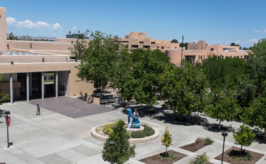 A man walks past the sculpture "Fiesta Dancers" by Luis Jimenez, outside the Popejoy Hall performing arts center on the central campus of the University of New Mexico in Albuquerque.