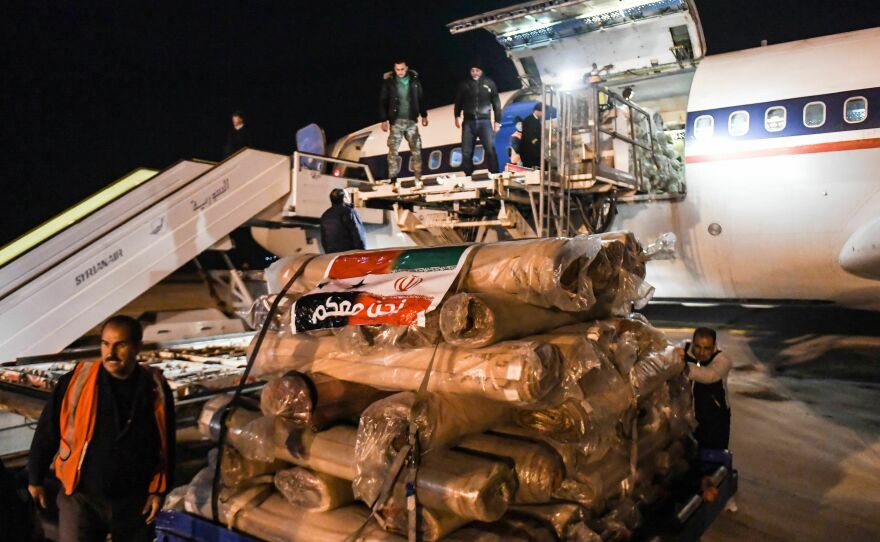 Workers unload an airplane with aid sent from Iran, at the Aleppo airport in Syria early on Wednesday.