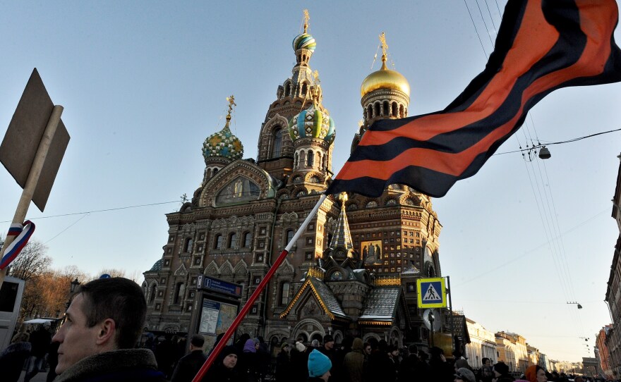 A pro-Kremlin activist holds a huge St. George's Ribbon, a well-known Russian symbol of military valor, during a rally in St. Petersburg, on March 18, to celebrate the incorporation of Crimea.