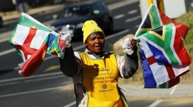 A woman sells national flags to drivers in the streets of northern Johannesburg on Sunday.