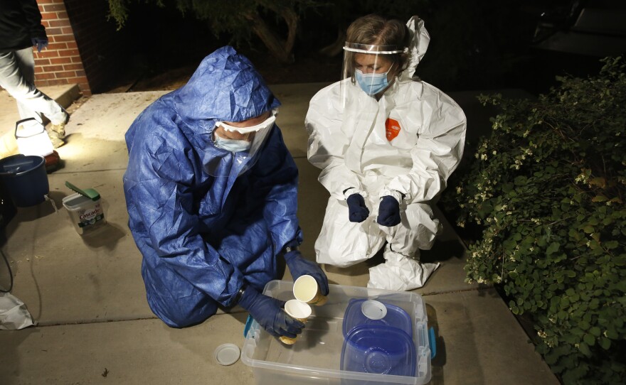 Bruder (right) and her colleague, environmental science professor Miroslav Kummel, pour wastewater samples from to-go coffee cups outside South Hall.