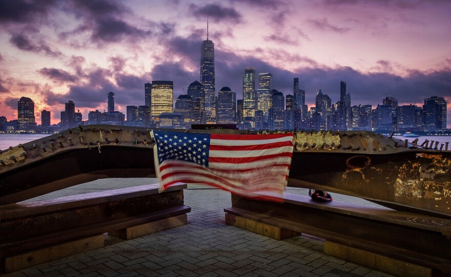 A U.S. flag hanging from a steel girder, damaged in the Sept. 11, 2001 attacks on the World Trade Center, blows in the breeze at a memorial in Jersey City, N.J., Sept. 11, 2019. 