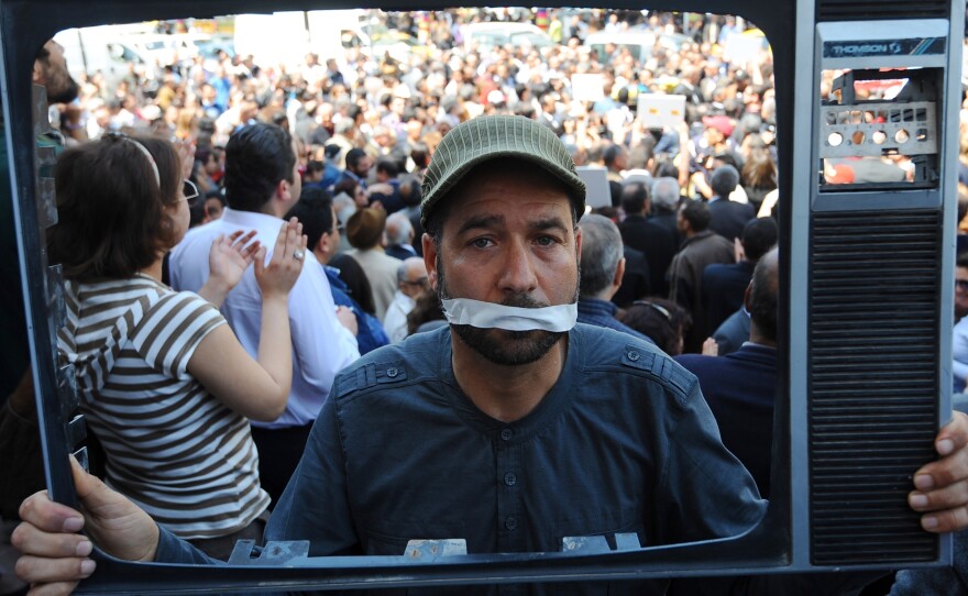 A Tunisian journalist holds a TV frame as part of a protest in Tunis against actions taken against the media. Since last year's revolution, Tunisians have been able to speak more freely about politics and social issues. But with the rise of Islamist groups, religion has become a more sensitive topic.