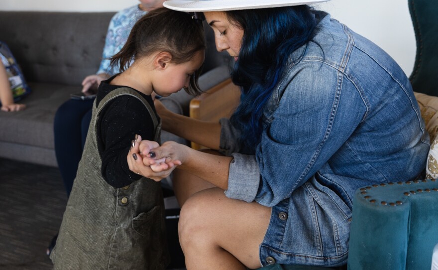 Melisa Alexandra Castro and her daughter, Michelle, 3, hold hands as they wait for the musical playgroup program to begin at The Music Therapy Center in Kearny Mesa on Nov. 19, 2022.