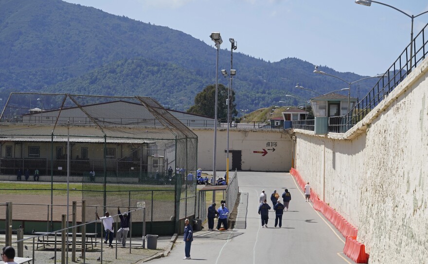 File photo of inmates gathering and walking near the exercise yard at San Quentin State Prison on April 12, 2022, in San Quentin, Calif.