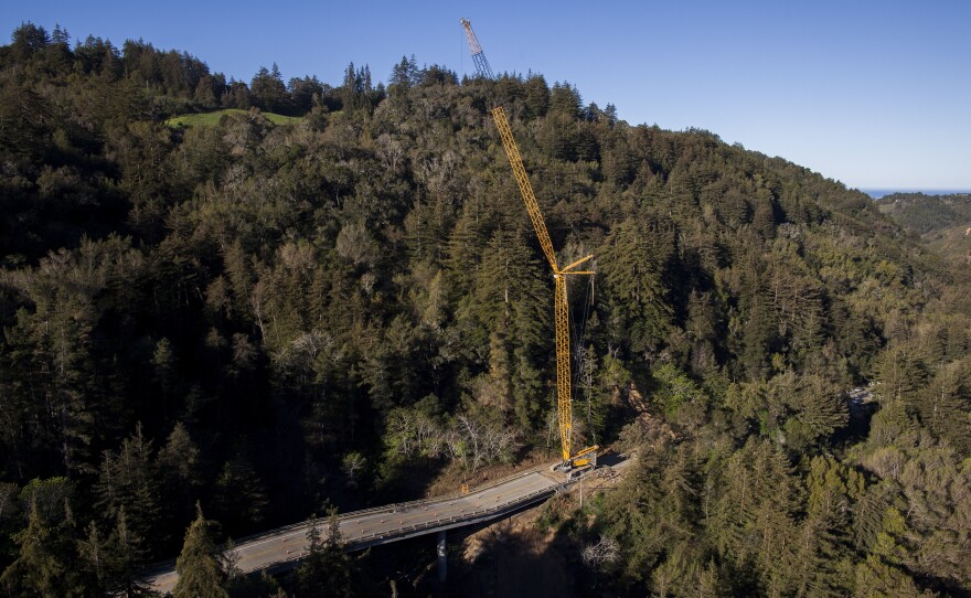 A crane sits on Highway 1 south of the Pfeiffer Canyon Bridge in Big Sur, Calif. Residents are adjusting after the bridge on the Central California coast crumbled last month in heavy rains, splitting the touristy Big Sur area in two, March 13, 2017. 