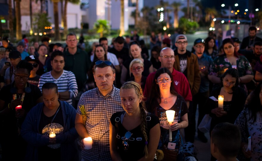 Mourners attend a candlelight vigil at the corner of Sahara Avenue and Las Vegas Boulevard for the victims of Sunday night's mass shooting in Las Vegas.