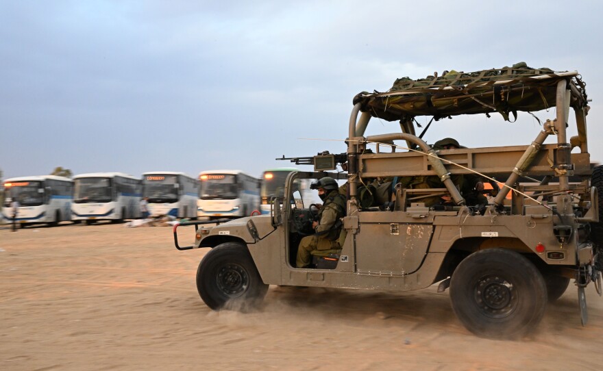 Israeli soldiers and vehicles at a gas station.