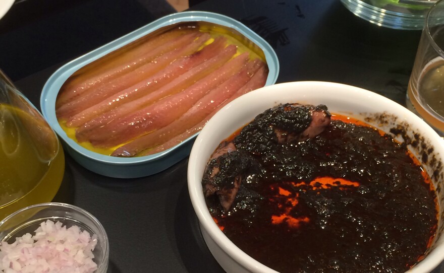 The writer's meal included anchovies and baby squid in their own ink, served with sides of bread and small bowls of salad greens, chopped onions and peppers.