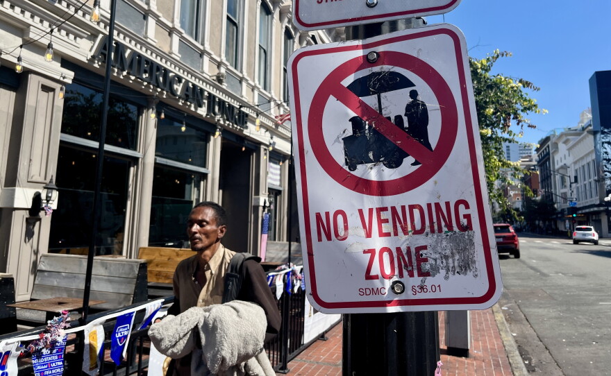 A man walks past a "No Vending Zone" sign in downtown San Diego, July 7, 2026.