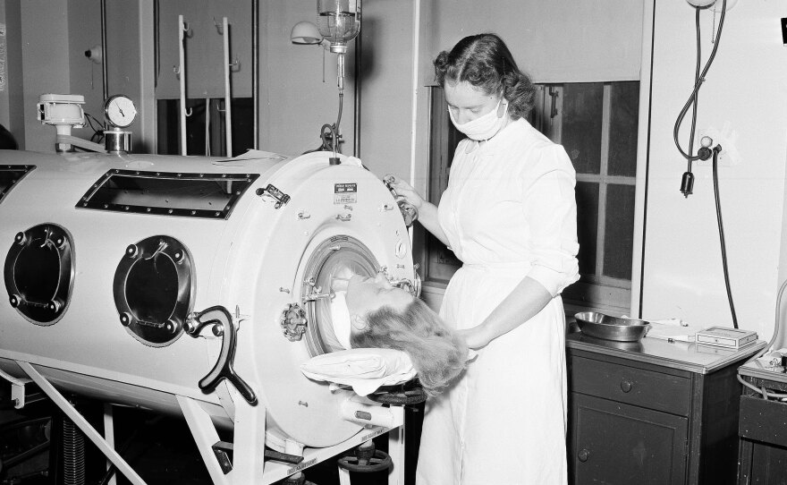 A nurse assists a 27-year-old patient in an iron lung in Syracuse, N.Y. in 1954.