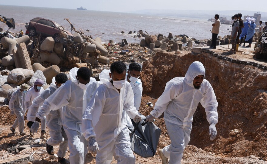 Volunteer Hossam Almegassabe and others carry a body recovered after being swept out to the sea during floods in Derna, Sept. 16.