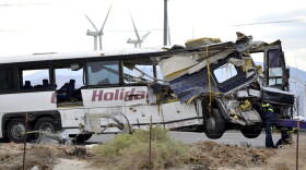 Workers prepare to haul away a tour bus that crashed with semi-truck on Interstate 10 just west of the Indian Canyon Drive off-ramp, in Desert Hot Springs, near Palm Springs, Oct. 23, 2016.