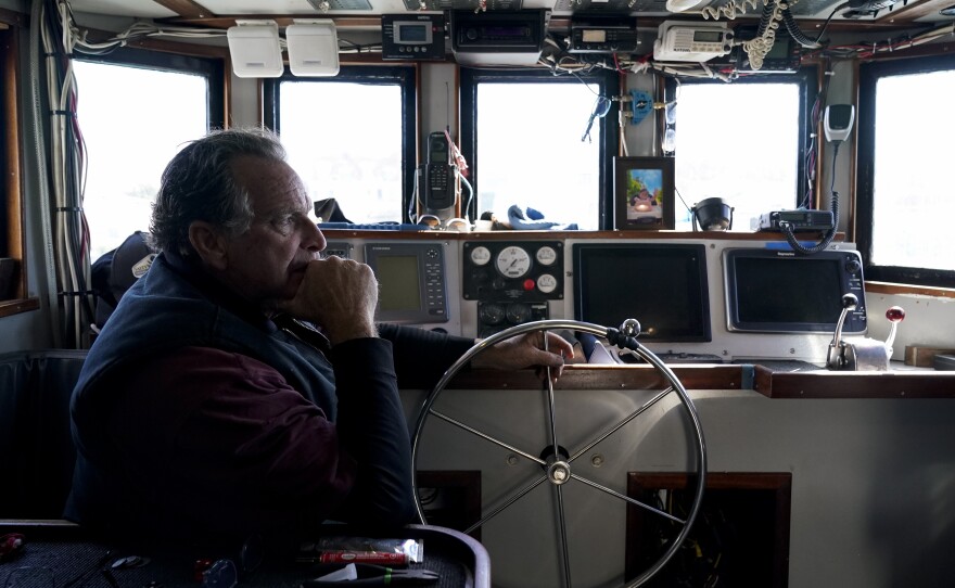 Bob Maharry sits inside his fishing boat docked at Pier 45 in San Francisco, Monday, March 20, 2023. This would usually be a busy time of year for Maharry and his crew as salmon fishing season approaches. On April 7, the Pacific Fishery Management Council, the regulatory group that advises federal officials, will take action on what to do about the 2023 season for both commercial and recreational salmon fishing.