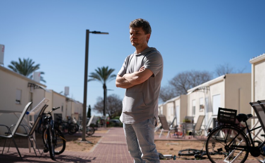 Avidor Schwartzman, 38, stands in front of a trailer park for survivors of the Oct. 7 attack, in Shefayim, Israel, on Tuesday. His family was moved from a hotel to one of these prefab homes two weeks ago. His wife's parents, Cindy and Igal Flash, were killed in the attack.