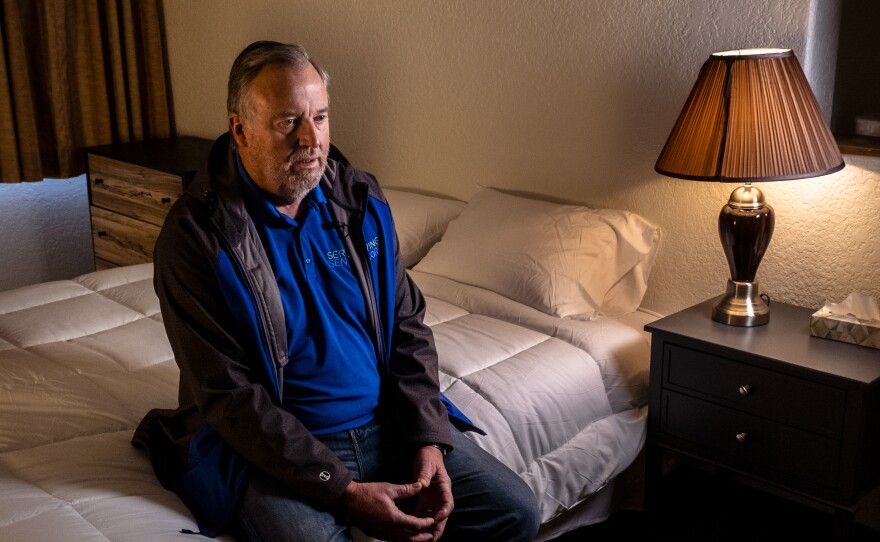 Serving Seniors CEO Paul Downey sits on a bed in a room at his organization's new transitional housing facility downtown, Jan. 26, 2023.