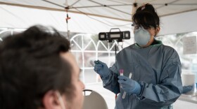 A healthcare worker wears a mask, gown and gloves in this undated photo. (Courtesy of Neighborhood Healthcare)