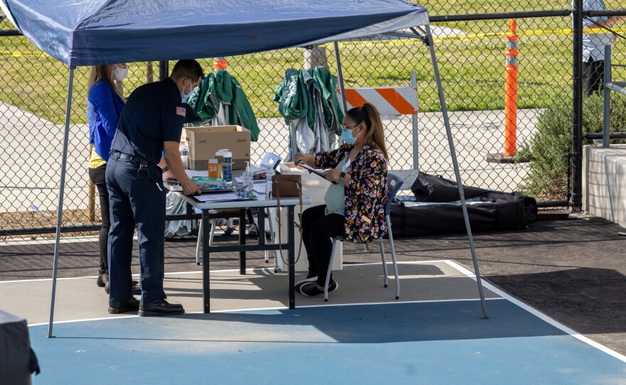 A firefighter arranges paperwork for COVID-19 vaccinations, April 2, 2021.