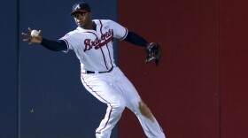 Atlanta Braves left fielder Justin Upton (8) fields a ball with his bare hand during a baseball game against the Pittsburgh Pirates in Atlanta, Sept. 23, 2014.