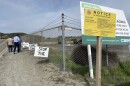 A group of Oceanside residents put up signs against the Eddie Jones Warehouse project near the warehouse site in Oceanside, Calif. February 17, 2023. 