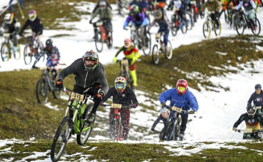 200 cyclists, some dressed in costumes, ride their bikes Saturday on the ski slopes during the start of the 33rd edition of the 'GP St-Sylvestre', a new-year snow mountain bike race, in the alpine resort of Villars-sur-Ollon, Switzerland.