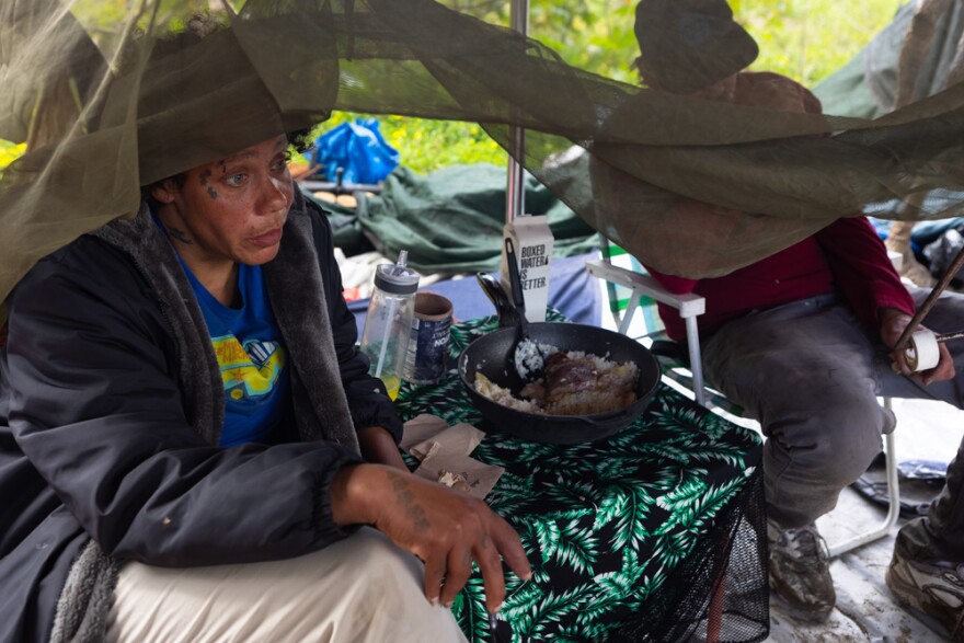 Tia Hitt and Jerrod Starbird eat lunch on an island in the San Diego River, March 25, 2024.