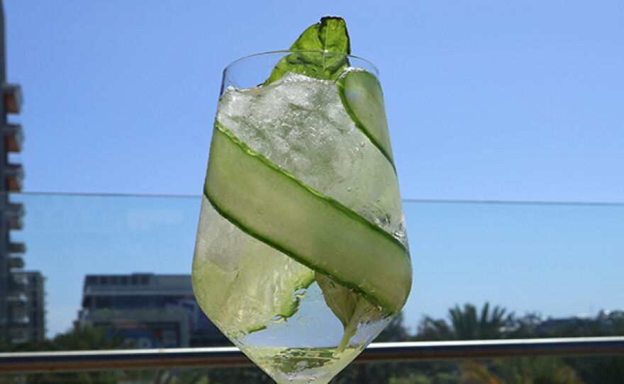 Santorini Spritz: A crisp cocktail pairing St. Germaine, Domaine Nerantzi Assyrtiko, fresh lemon juice, honey simple, cucumber, basil, and soda water.