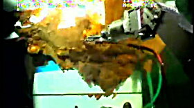 A robotic arm from a submersible works around the leaking Gulf of Mexico wellhead in this still image from a live BP video feed.