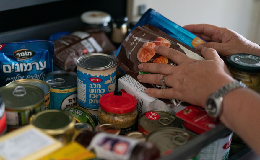 Neta Kahan, 52, shows the extra dried goods and canned foods her family bought in preparation for a possible war with Hezbollah in Lebanon, in her home in Rishpon, Israel.