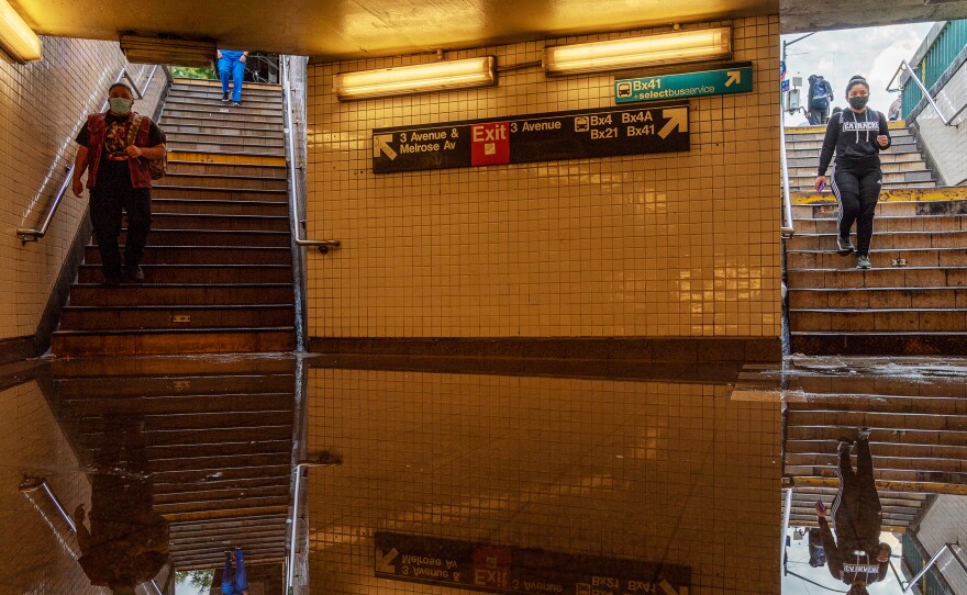 Commuters head into New York's Third Avenue-149th Street subway station on Thursday. Heavy rain from remnants of Hurricane Ida flooded much of the city's subway system. Authorities issued a travel ban and warned residents to avoid stations.