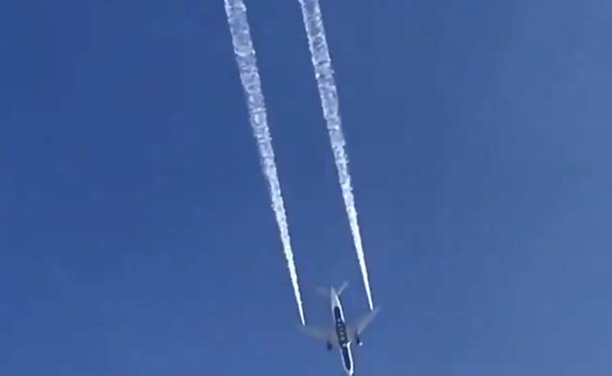 In this image from video, a Delta plane dumps fuel over Los Angeles before returning for an emergency landing on Tuesday. Fire officials say fuel fell onto an elementary school playground.