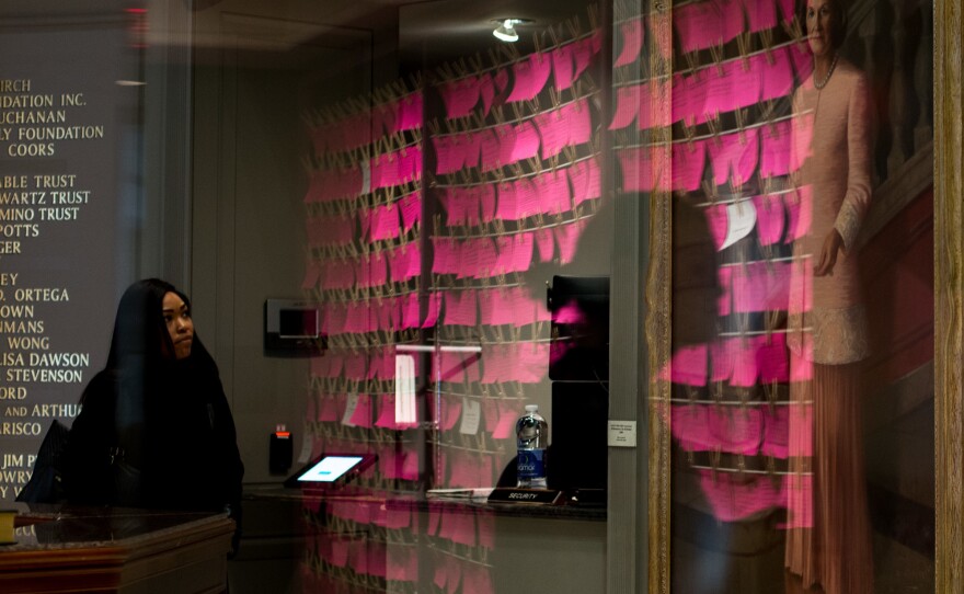 A reflection of pink index cards that are part of the Clothesline Project at the National Museum of Women in the Arts.