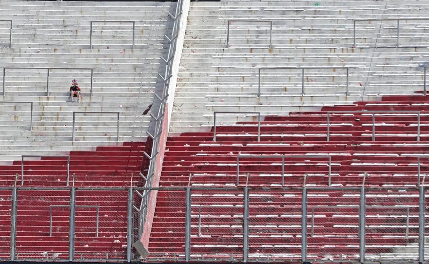 A River Plate fan sits on an empty stand at the Monumental Stadium in Buenos Aires, after the all-Argentine Copa Libertadores second leg final match against Boca Juniors was postponed on Sunday for the second time following an attack on the Boca team bus by River fans.