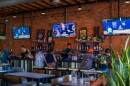 Customers sitting at the bar watch women's basketball and softball at One of Us in North Park on July 22, 2026. One of Us is San Diego's first women's sports bar.