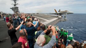 Sailors’ friends and family watch an F/A-18C Hornet, assigned to Strike Fighter Squadron (VFA) 25 launch from the flight deck of the Nimitz-class aircraft carrier USS Carl Vinson (CVN 70) during the ship's Tiger Cruise air show. Carl Vinson and Carrier Air Wing (CVW) 17 recently completed a deployment the U.S. 5th Fleet and U.S. 7th Fleet areas of responsibility, June 11, 2011.