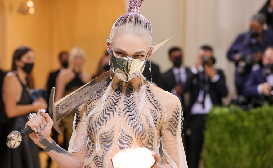 Grimes describes her Iris van Herpen gown, dubbed the "Bene Gesserit" dress, as "<em>Dune</em>-esque." She accompanied the look with a face mask borrowed from the <em>Dune</em> film set and a medieval-style sword.