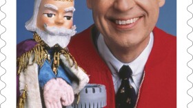This image released by the United States Postal Service shows a postage stamp featuring Fred Rogers from the PBS children's television series "Mister Rogers' Neighborhood" with his King Friday XIII puppet. 